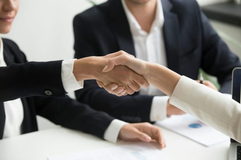 Business handshake symbolizing employment contract transfer in Turkey